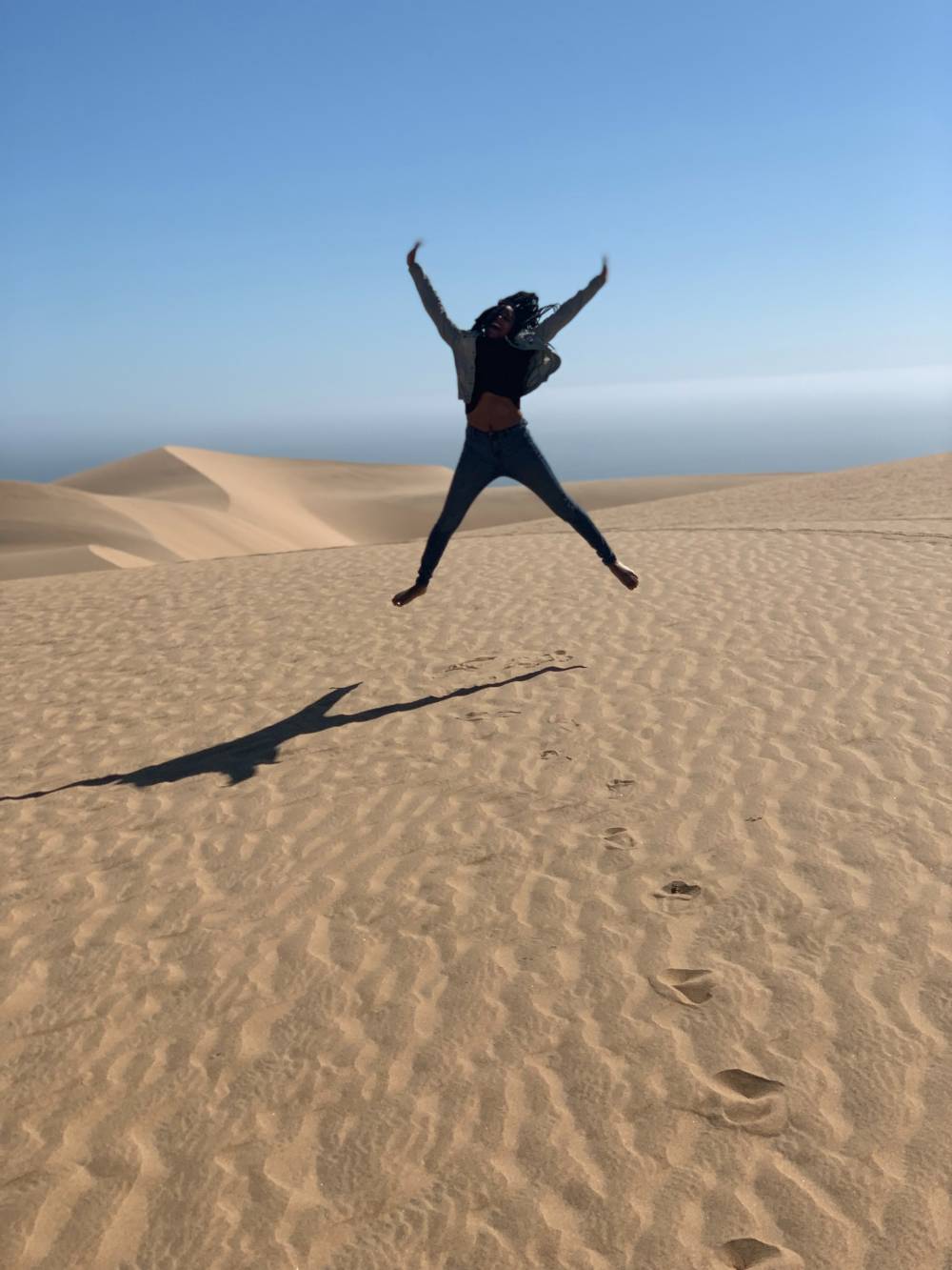 Student jumping on the dunes